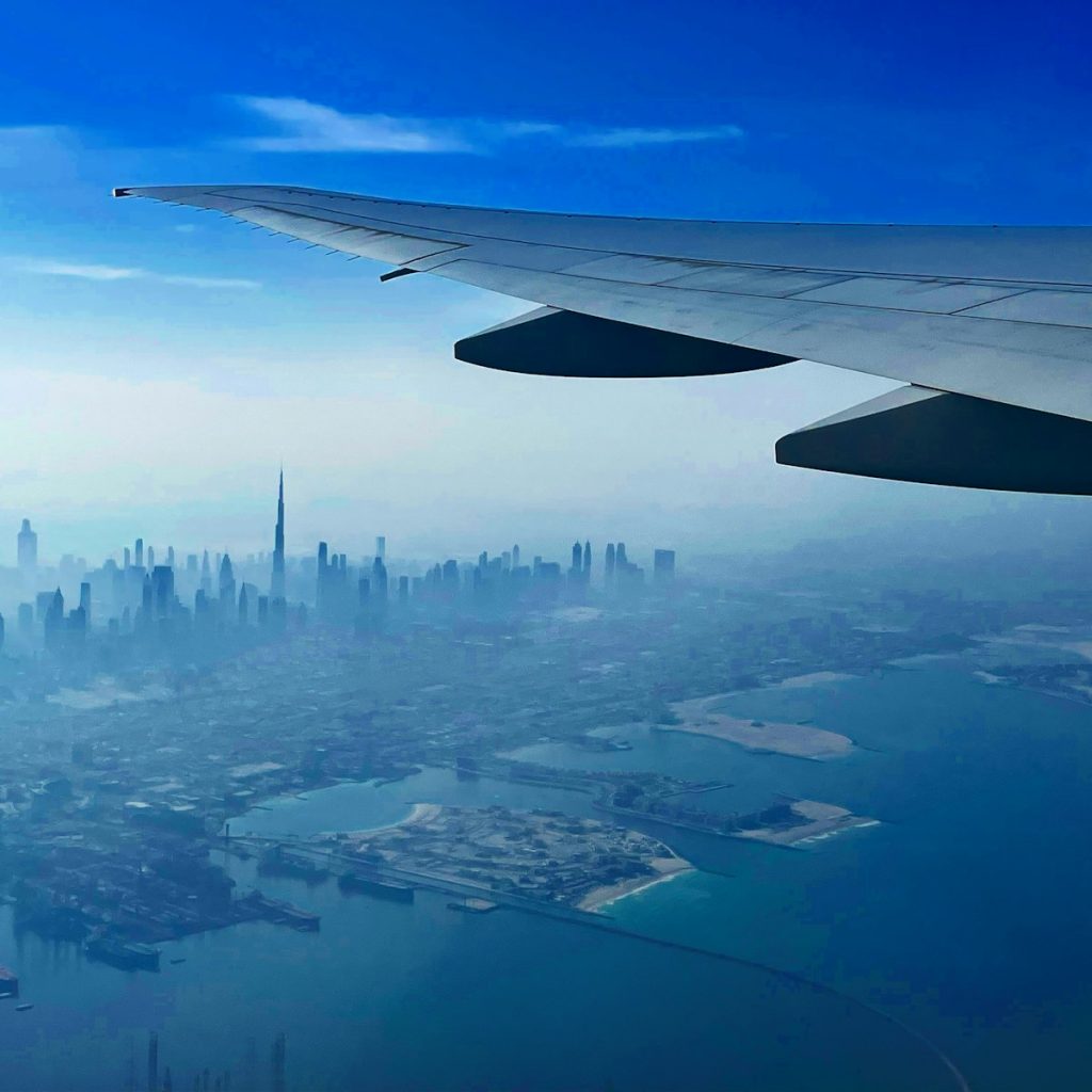 the wing of an airplane flying over a city